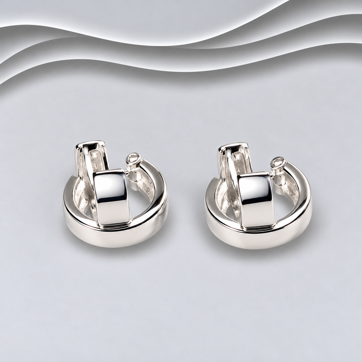 Pair of polished 925 sterling silver chunky huggie hoop earrings with broad front sections and hinged fastenings